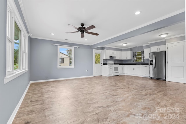 unfurnished living room with crown molding, a healthy amount of sunlight, sink, and ceiling fan