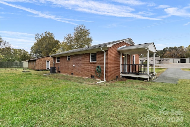 view of property exterior featuring central air condition unit and a yard