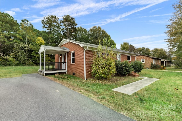 view of side of property with covered porch and a yard