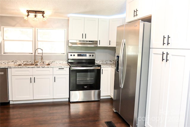 kitchen featuring white cabinets, light stone counters, appliances with stainless steel finishes, a textured ceiling, and sink