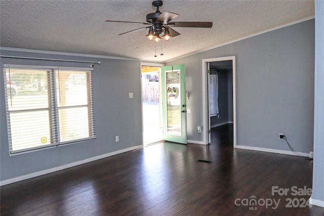 spare room featuring dark hardwood / wood-style flooring, ornamental molding, a textured ceiling, and a wealth of natural light