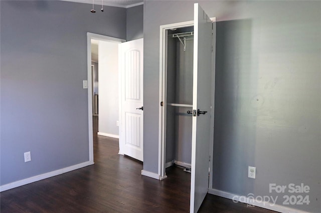 unfurnished bedroom with dark hardwood / wood-style floors and a closet