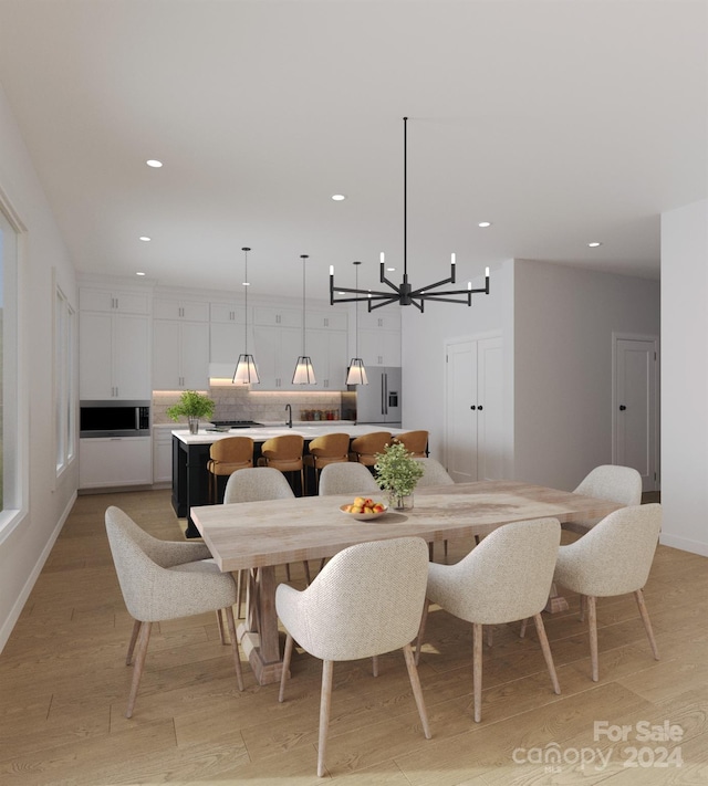 dining room with light hardwood / wood-style flooring and an inviting chandelier