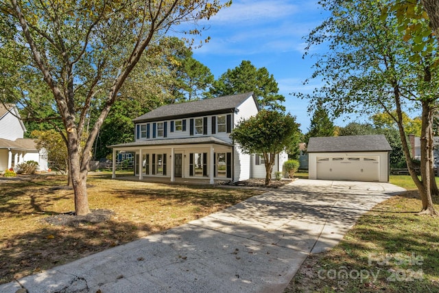 view of front facade with covered porch, an outdoor structure, a front yard, and a garage