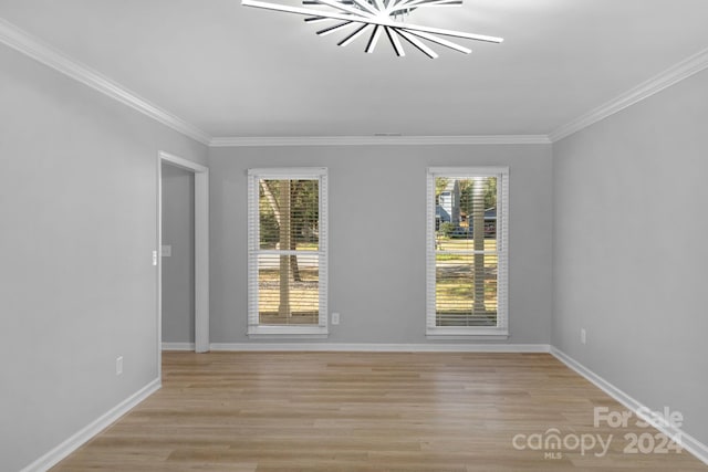 empty room with light hardwood / wood-style floors, a notable chandelier, and ornamental molding