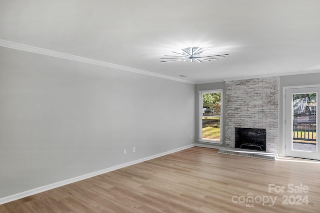 unfurnished living room with crown molding, light hardwood / wood-style flooring, and a fireplace