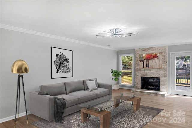 living room with ornamental molding, hardwood / wood-style floors, and a brick fireplace