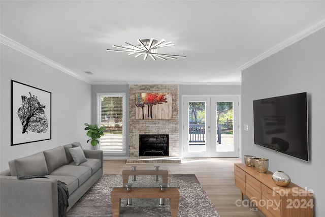 living room with a wealth of natural light, ornamental molding, and light wood-type flooring