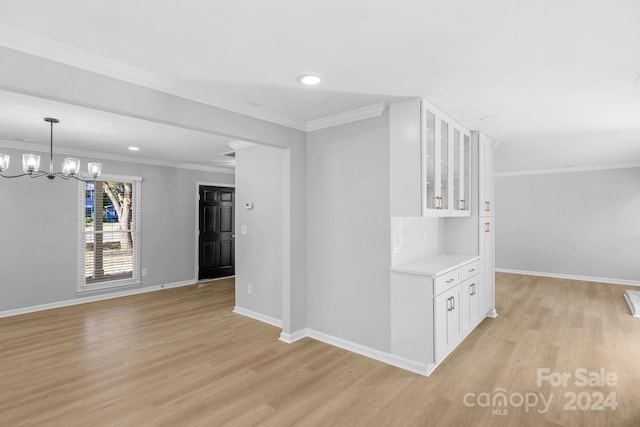 interior space featuring ornamental molding, a notable chandelier, and light wood-type flooring