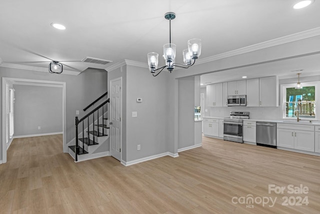 kitchen featuring ornamental molding, white cabinets, light hardwood / wood-style flooring, and stainless steel appliances