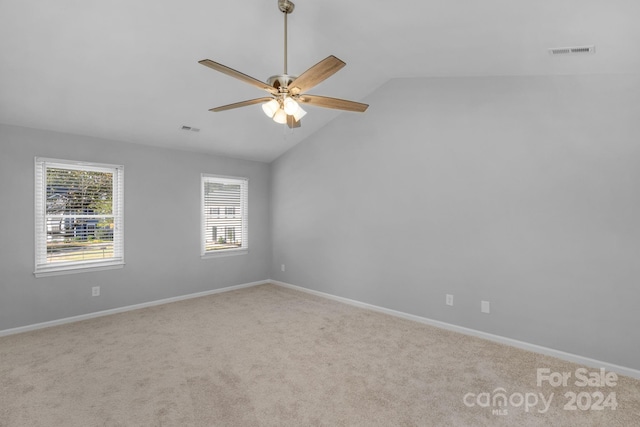 carpeted spare room with ceiling fan and lofted ceiling