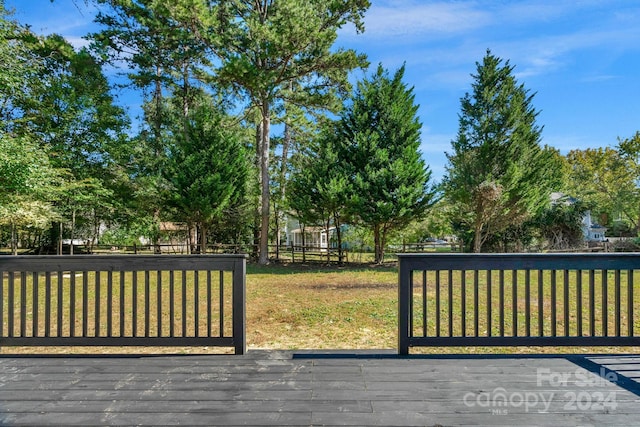 wooden terrace featuring a yard