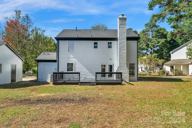 rear view of house featuring a deck and a lawn