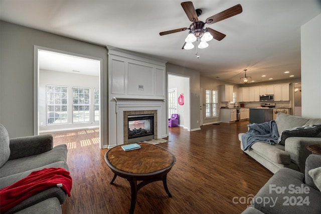 living room with a fireplace, dark hardwood / wood-style floors, and ceiling fan