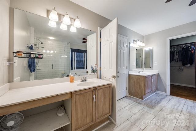 bathroom with ceiling fan, a shower with door, and vanity