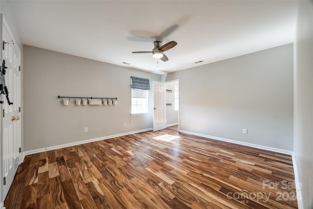 empty room with hardwood / wood-style floors and ceiling fan