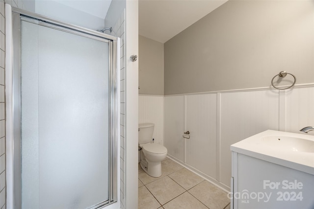 bathroom with tile patterned floors, toilet, an enclosed shower, and vanity