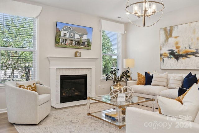 living room with a notable chandelier, a high end fireplace, and hardwood / wood-style floors