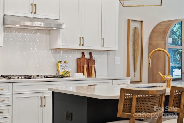 kitchen with stainless steel gas cooktop, tasteful backsplash, and white cabinets