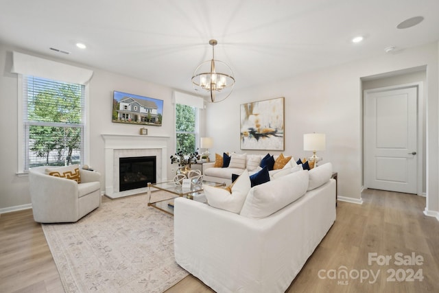 living room with an inviting chandelier and light hardwood / wood-style flooring