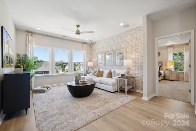 living room featuring light hardwood / wood-style flooring, ceiling fan, and a wealth of natural light