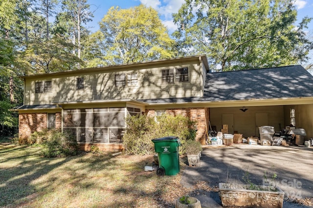 back of house with a yard and a sunroom