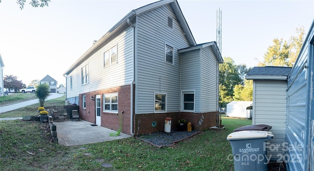 back of house with a lawn and a patio area