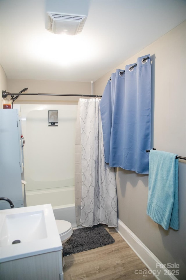 full bathroom featuring wood-type flooring, vanity, shower / tub combo with curtain, and toilet