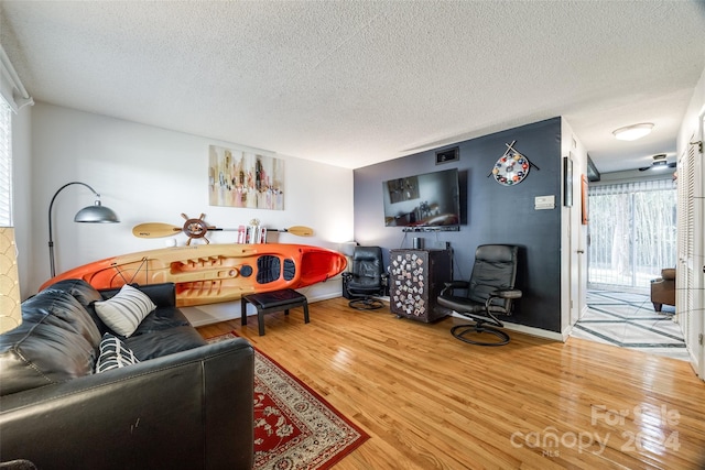 living room with a textured ceiling and wood-type flooring