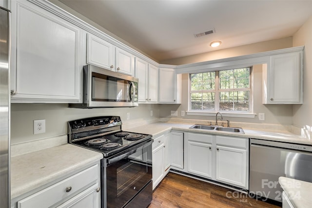 kitchen featuring sink, appliances with stainless steel finishes, white cabinetry, and dark hardwood / wood-style flooring