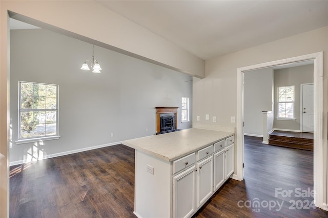 kitchen featuring a wealth of natural light, white cabinets, kitchen peninsula, and dark hardwood / wood-style floors