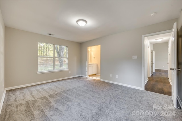 unfurnished bedroom featuring carpet and ensuite bath