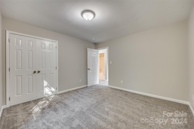 unfurnished bedroom featuring carpet flooring and a closet