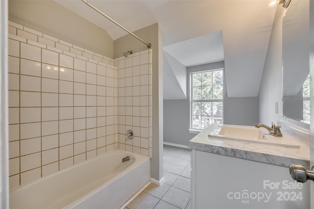 bathroom with vanity, vaulted ceiling, tile patterned flooring, and tiled shower / bath