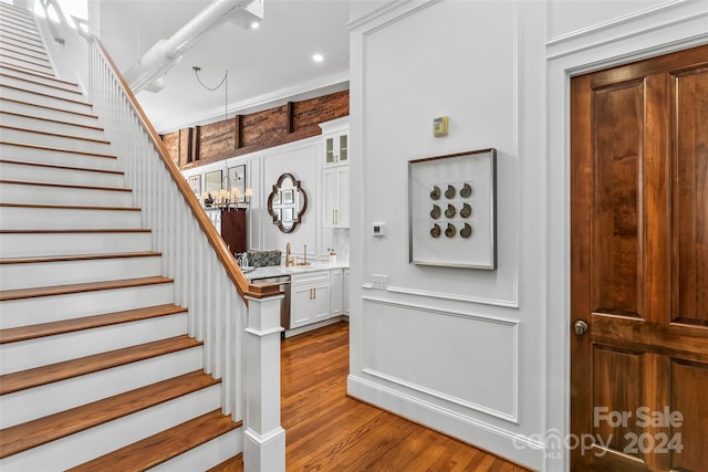 stairway featuring hardwood / wood-style floors and crown molding