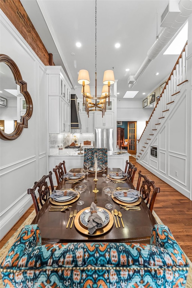 dining room with a notable chandelier, ornamental molding, and hardwood / wood-style flooring