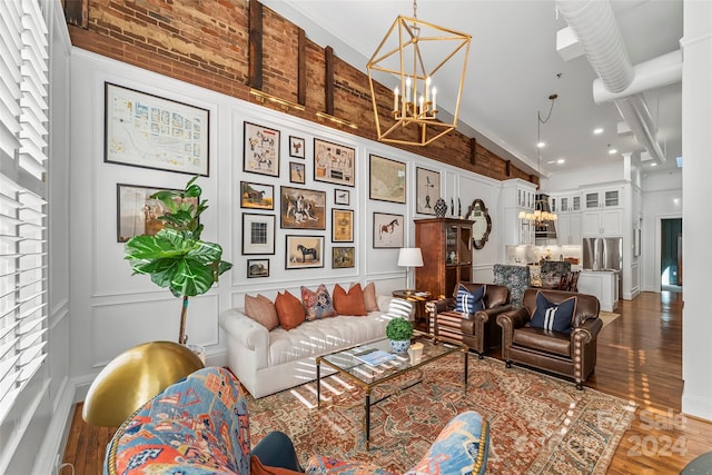living room with wood finished floors, a high ceiling, and a notable chandelier