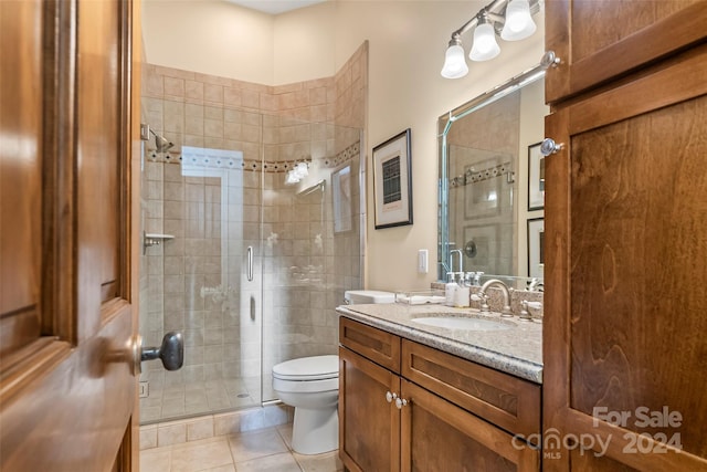 bathroom featuring vanity, toilet, tile patterned flooring, and an enclosed shower