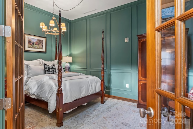 bedroom featuring a chandelier, wood finished floors, a decorative wall, and visible vents