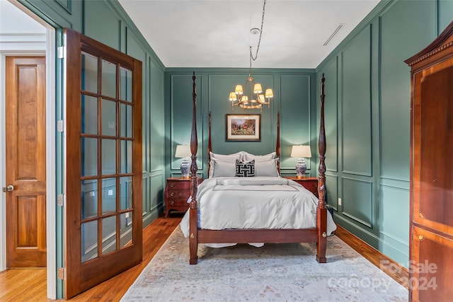 bedroom featuring an inviting chandelier and light wood-type flooring