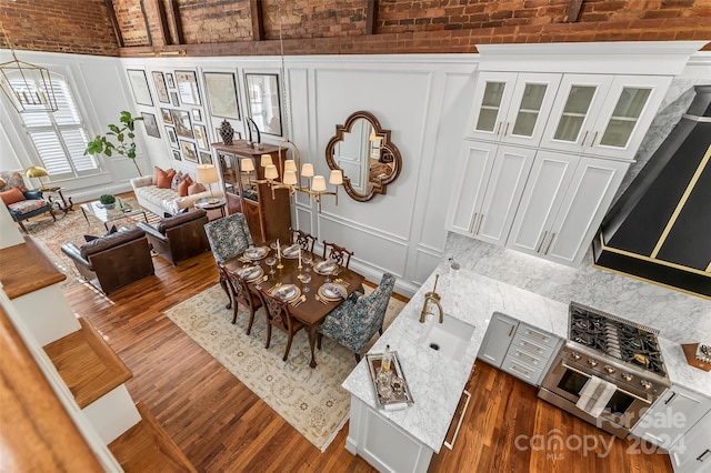 dining space featuring brick ceiling, a decorative wall, and dark wood-style floors