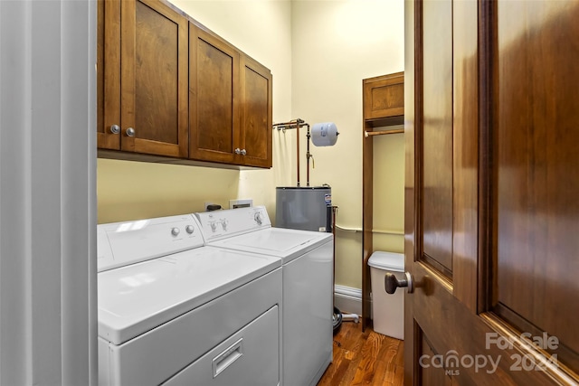 laundry room featuring washing machine and dryer, dark hardwood / wood-style flooring, water heater, and cabinets