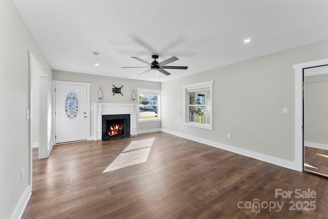 unfurnished living room with ceiling fan, dark hardwood / wood-style floors, and a brick fireplace