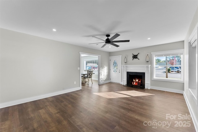 unfurnished living room featuring ceiling fan, hardwood / wood-style flooring, and a brick fireplace