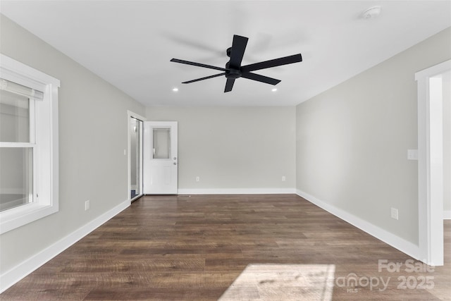 spare room with dark hardwood / wood-style flooring and ceiling fan