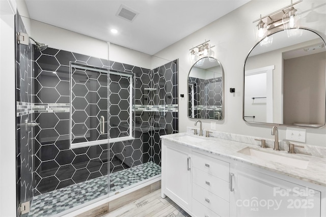 bathroom with vanity, hardwood / wood-style flooring, and a shower with shower door