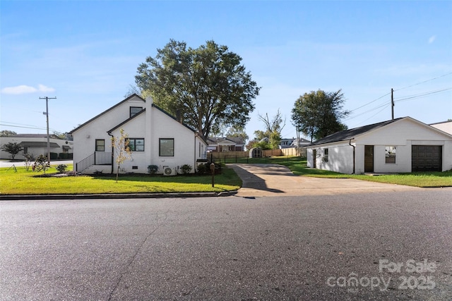 view of side of property featuring a lawn, a garage, and an outdoor structure