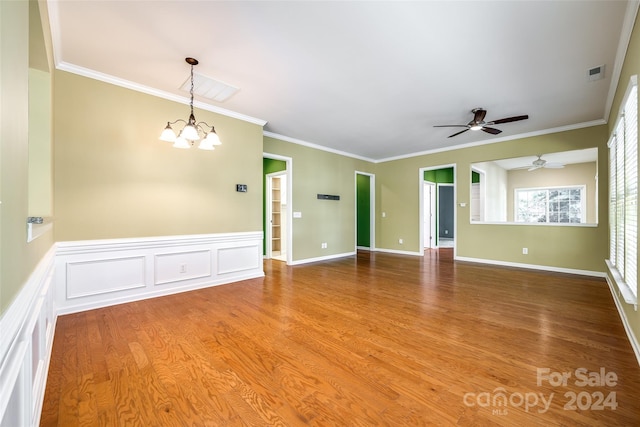 unfurnished room with crown molding, wood-type flooring, and ceiling fan with notable chandelier