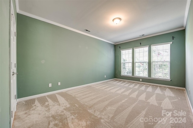 unfurnished room featuring ornamental molding and light colored carpet