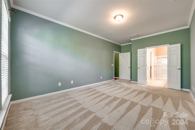 unfurnished bedroom with ornamental molding and light colored carpet